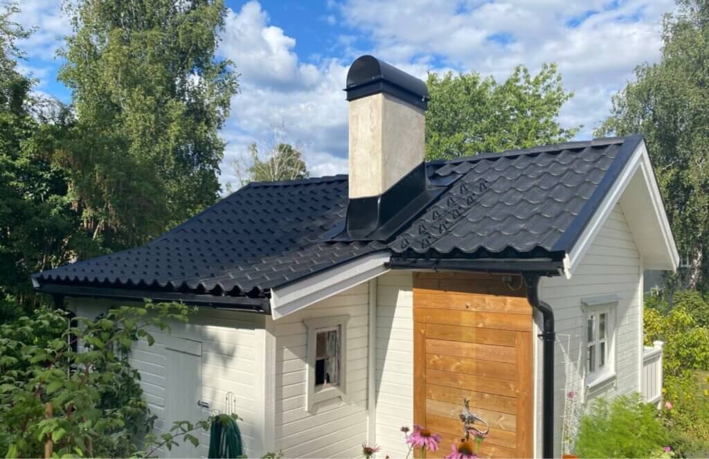 Takomläggning i Stockholm där nya svarta takplattor lades på ett litet vitt hus